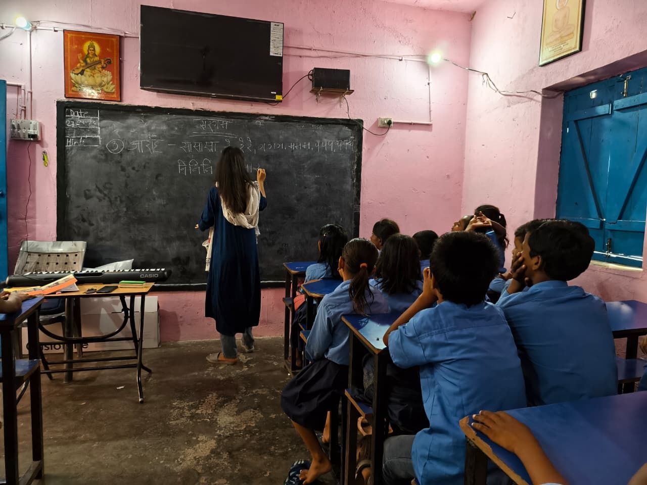 A facilitator teaching a music session to a class of school students